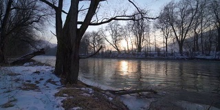 宁静的早晨与日出在河岸上的树木多莉拍摄