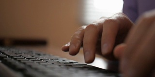 特写商人在电脑键盘上打字。男人的手忙着在键盘上打字。黑客的学生。缓慢的运动。