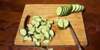 切黄瓜。在木砧板上切碎的蔬菜的特写。定格动画