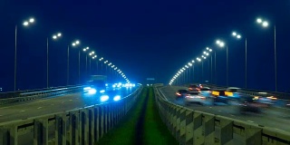 公路交通车辆在夜间时间流逝。汽车在桥上行驶的晚上时间流逝。4 k UHD