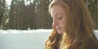 一个美丽的年轻女子在一个下雪的日子戴着一顶无檐帽的侧面照片