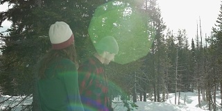 慢动作拍摄的一对年轻的爱的夫妇在一起散步，而手牵手在一个下雪的日子。然后镜头向上平移