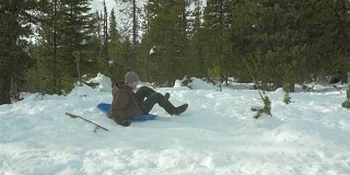 一个年轻人骑着雪橇跳过一座雪山的慢动作镜头。