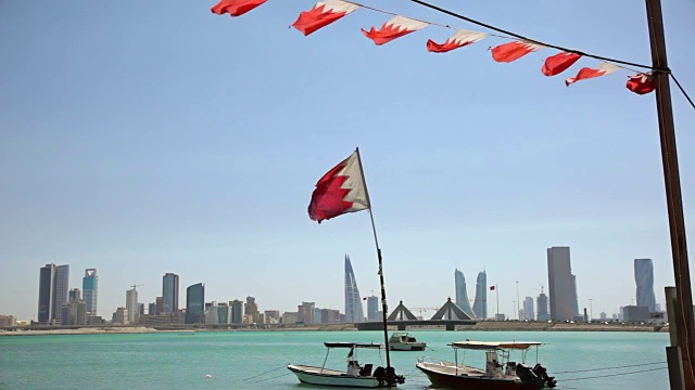 巴林。渔船，旗帜和麦纳麦天际线