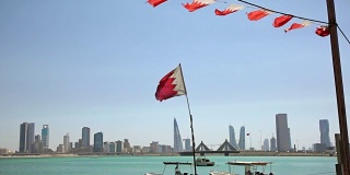 巴林。渔船，旗帜和麦纳麦天际线