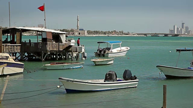 巴林。渔民的房子和船。麦纳麦天际线