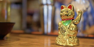 韩国餐厅吧台上的金色幸运猫颈猴