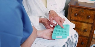 护士帮助老年妇女在家服药的特写