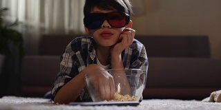 孩子戴着3d眼镜看电影，吃着爆米花，父母玩忽职守，慵懒休闲