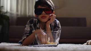 孩子戴着3d眼镜看电影，吃着爆米花，父母玩忽职守，慵懒休闲视频素材模板下载