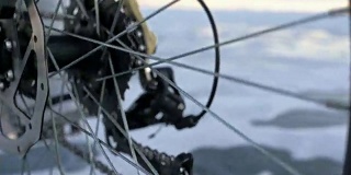 看轮胎。180 fps射击。一个女人在冰上骑自行车。结冰的贝加尔湖的冰。自行车的轮胎上覆盖着特殊的尖钉。