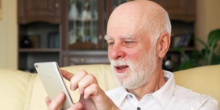 老人在家用手机，浏览，看新闻。退休后活跃的现代生活