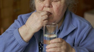 年长女性在家吃药视频素材模板下载