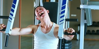 滑稽的亚洲人正在健身房用滑稽和幽默的表情锻炼
