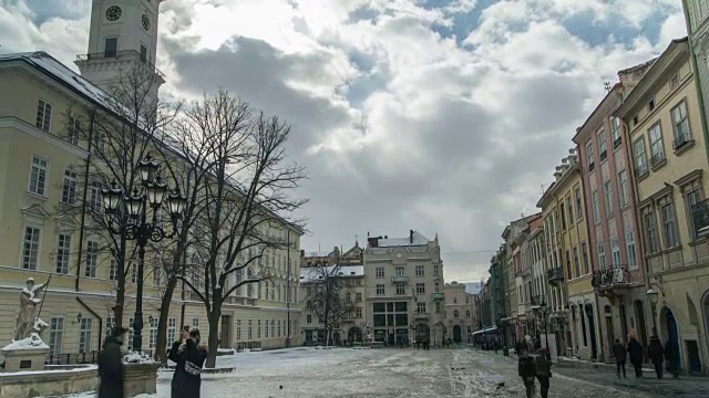 乌克兰利沃夫- 2018冬季:乌克兰利沃夫老城中心。在市政厅附近的市场广场(Ploshcha Rynok)移动的人们的时间流逝。云移动得很快。