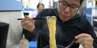 香港，一名男子在当地餐馆吃鸡蛋面。