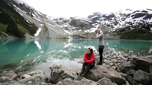 徒步旅行后，两个女人在乔佛湖边休息。