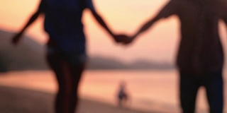 模糊的背景浪漫的夫妇跑在海滩上在惊人的日落手牵手。缓慢的运动。1920 x1080