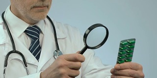 Physician examining medicine with magnifier, new experimental drug development