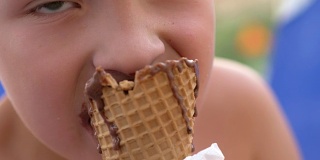 男孩在吃巧克力冰淇淋蛋卷