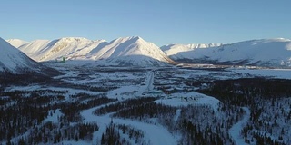 无人机在高山雪山针叶树上空向前飞行。相机正在向上倾斜。鸟瞰图。远景。