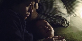 亚洲男婴睡在室内床上，母亲在家。