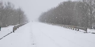 冬天的赛道道路上，汽车行驶的是非常大雪户外暴风雪暴风雪