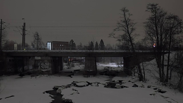 冬季城市的旅客列车在大桥上运行的夜景