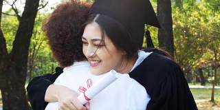 年轻的亚洲女学生戴着毕业帽和毕业礼服在大学，女性与毕业概念。怀着快乐的心情拥抱母亲的女人。