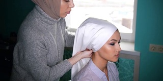 两名穆斯林妇女系上伊斯兰头巾，准备举行婚礼