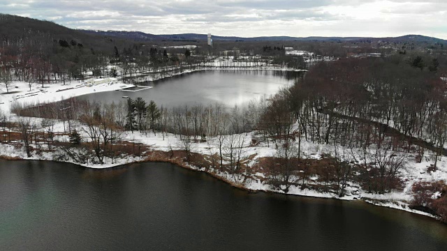 新泽西州伦道夫郊区丘陵湖泊下雪的航拍视频