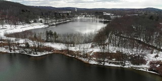 新泽西州伦道夫郊区丘陵湖泊下雪的航拍视频