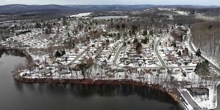 新泽西州伦道夫郊区丘陵湖泊下雪的航拍视频