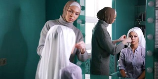 两名穆斯林妇女系上伊斯兰头巾，准备近镜举行婚礼