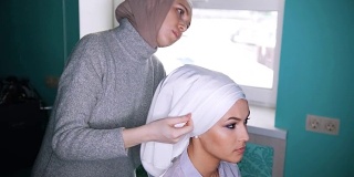 一个穆斯林妇女正在为美丽的模特系头巾