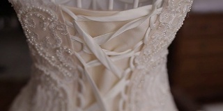 华丽的婚纱与紧身衣和亮片挂在复古人体模型的后视图。