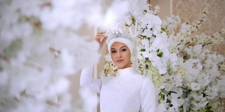 美丽的穆斯林新娘在白色婚纱和新娘头饰