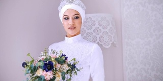 美丽的模特白色穆斯林婚纱和新娘头饰与鲜花