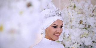 微笑的穆斯林新娘新娘用鲜花新娘化妆