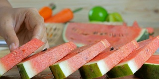 Close up shot hands of woman arranging a piece ripe watermelon on wooden cut board fresh  fruit for summer