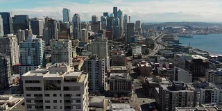 无人机拍摄转身和飞越西雅图市中心，华盛顿揭示滨水区，体育场馆，和城市的建筑。