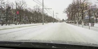 一场大雪过后，汽车载着雪行驶在城市道路上