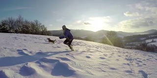一个女人带着她的狗跑上一座雪山的慢镜头