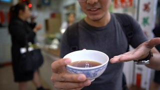 亚洲人在镜头前展示和品尝著名的中国凉茶视频素材模板下载