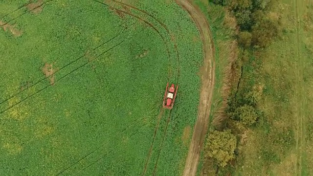 拖拉机在秋天给村舍附近的农田喷洒绿色农药