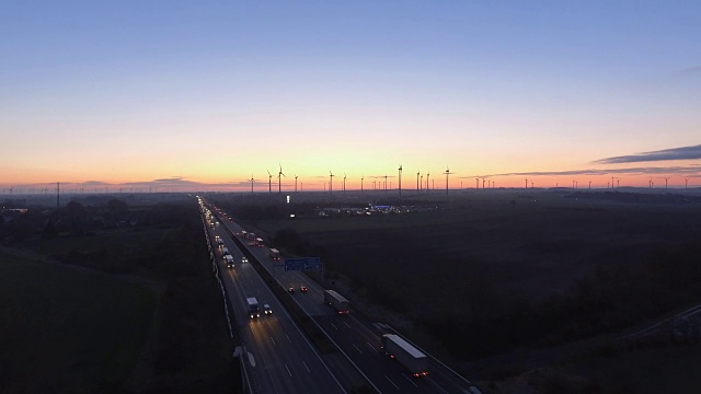 晨光越过农村公路交通，风力涡轮机，从鸟瞰的视角