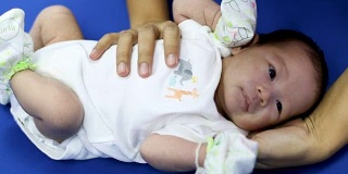 在医院的产房里，年轻的母亲抱着她刚出生的亚洲宝宝