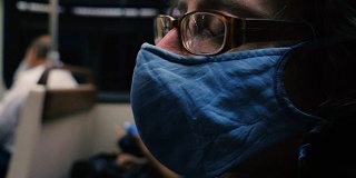 一名男子在公共场合戴着呼吸面罩睡在地铁里