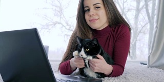 迷人的女主人和猫咪躺在电脑前休息
