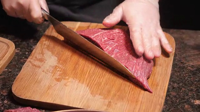 厨师在木板上切肉。餐厅里的新鲜生肉。有选择性的重点。